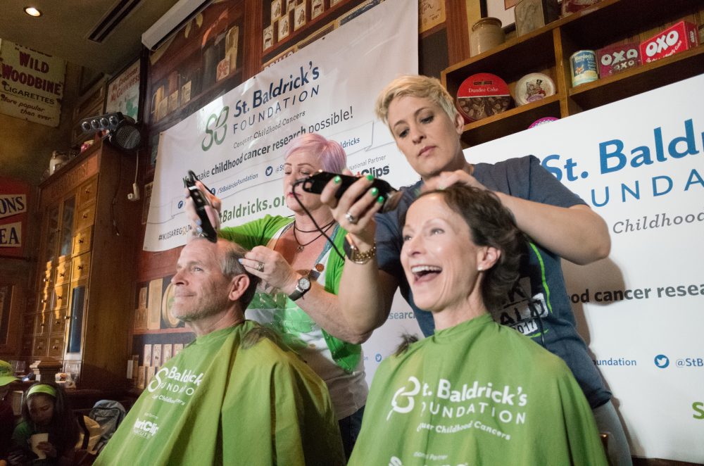 two people getting head shaved