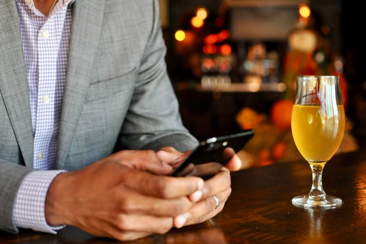man with beer and phone in hand